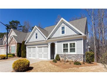 Charming home with gray siding, stone accents, manicured landscaping, and a two-car garage at 341 Little Pine Ln, Woodstock, GA 30188
