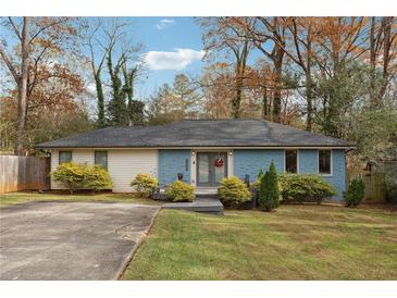 Charming single-story home featuring a light blue brick facade, well-maintained lawn, and mature trees at 2336 Mark Trl, Decatur, GA 30032