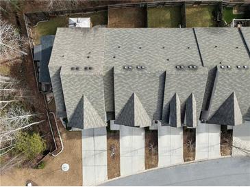 An aerial view of a townhouse complex showcases rooftops and driveway leading up to the garages at 3266 Spicy Cedar Ln, Lithonia, GA 30038