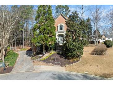 Charming two-story brick home featuring a manicured front yard and mature trees at 5043 Willeo Estates Dr, Marietta, GA 30068