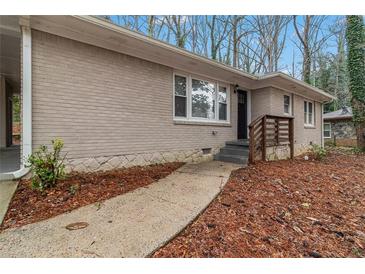 Charming one-story brick home with a walkway leading to the front door and a well-maintained yard at 1883 Windsor Sw Dr, Atlanta, GA 30311