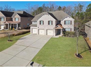 Traditional two-story home with a three-car garage and a well-manicured front lawn at 7686 Brazos Trl, Fairburn, GA 30213