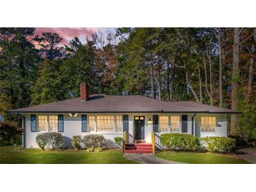 Charming home featuring a well-maintained lawn, complemented by mature trees and a classic brick chimney at 1403 Centra Villa Dr, Atlanta, GA 30311