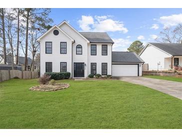 Charming white two-story home with a well-manicured lawn and black trim accents at 310 Mulberry Manor Ct, Johns Creek, GA 30005