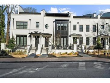 Charming white brick townhomes feature black window trim, entry stairs, and covered porch areas at 145 Canton St, Alpharetta, GA 30009