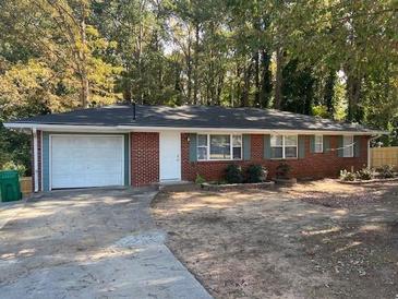 Charming red brick ranch home with attached garage and well-maintained front yard landscaping at 687 N Hairston Rd, Stone Mountain, GA 30083