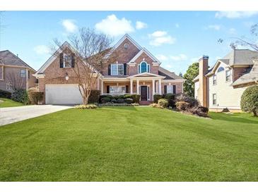 Charming two-story brick home with manicured lawn and inviting front porch at 1102 White Cloud Rdg, Snellville, GA 30078