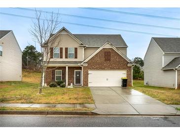 Two-story home with brick and tan siding, a two-car garage, and a well-maintained lawn at 2376 Allman Dr, Jonesboro, GA 30236