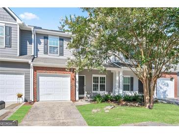 Charming two-story townhome with a one car garage and a well manicured lawn at 3032 Cedar Glade Ln, Buford, GA 30519