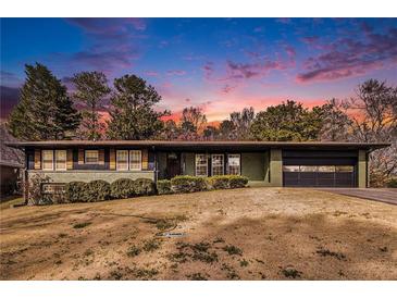 Charming single-story home with a well-manicured lawn and a lovely sunset backdrop at 635 Reed Se Rd, Smyrna, GA 30082