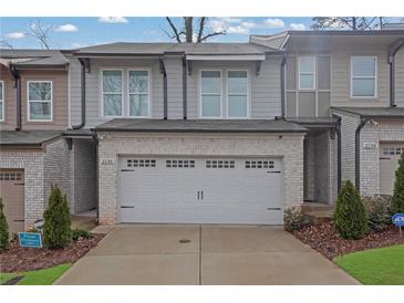 Charming townhome featuring a two-car garage, neutral siding, and manicured landscaping at 2136 Garden Pl, Atlanta, GA 30316