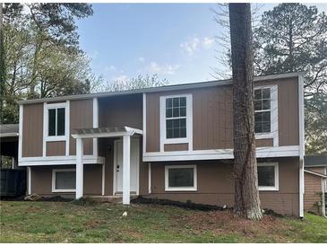 Two story home featuring a neutral color scheme with white trim, updated windows and front entry columns at 4941 Isle Royal Ct, Stone Mountain, GA 30088