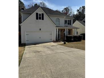 Charming two-story home features a two-car garage and inviting covered porch at 2162 Fall Creek Ldg, Loganville, GA 30052