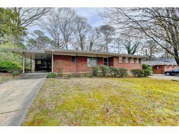 Charming brick home featuring a carport and a spacious front yard with mature trees at 2516 Warwick Ne Cir, Atlanta, GA 30345