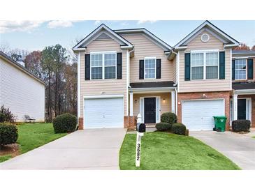 Charming townhome with a well-manicured lawn and single-car garage and inviting curb appeal at 3682 Harvest Dr, Decatur, GA 30034