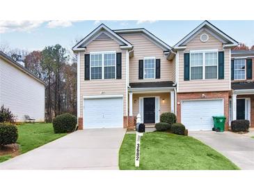 Inviting two-story townhome with a well-manicured lawn, single-car garage, and dark shutters at 3682 Harvest Dr, Decatur, GA 30034