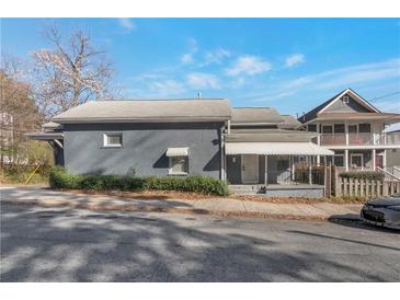 Quaint gray home featuring a covered front porch, mature shrubs, and a well-maintained facade on a sunny day at 235 Dodd Sw Ave, Atlanta, GA 30315