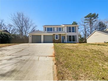 Split-level home featuring two-car garage, neutral colors, and large windows at 901 Chapman Cir, Stone Mountain, GA 30088