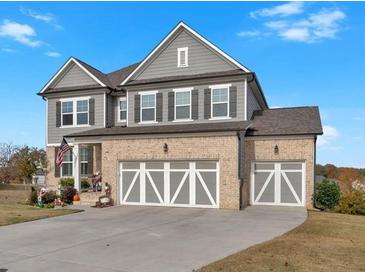 Beautiful two-story home featuring a brick facade, gray siding and a three-car garage at 12 Ridgeline Nw Way, Cartersville, GA 30121