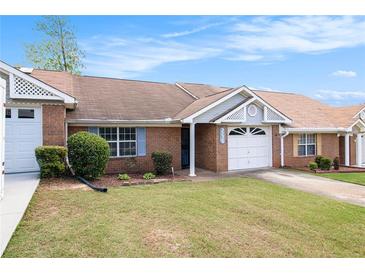 Charming brick home with a well-maintained lawn, attached garage, and inviting entrance at 256 Olde Oaks Ln, Riverdale, GA 30274