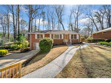 Charming brick home featuring manicured front lawn, inviting walkway, and classic architectural details at 750 Parkway Se Dr, Smyrna, GA 30080