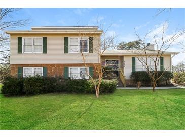 Charming home featuring a well-manicured lawn and inviting front entrance, perfect for a Gathering at 4055 S Bogan Rd, Buford, GA 30519