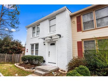 Charming two-story home with a white painted brick facade and well-maintained landscaping at 8834 Applegate Ln, Atlanta, GA 30350