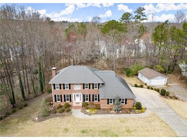 A charming two-story home with black shutters, a brick facade, and a well-manicured lawn at 5020 Puritan Dr, Sugar Hill, GA 30518