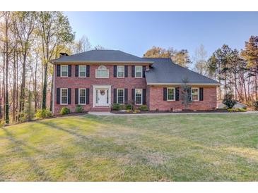 Traditional brick home with manicured lawn and symmetrical facade exudes curb appeal at 5020 Puritan Dr, Sugar Hill, GA 30518