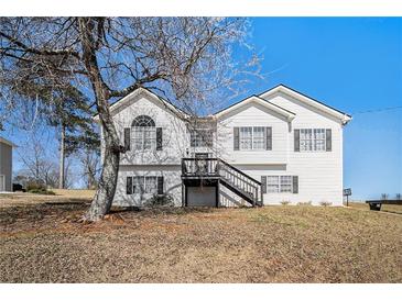 Charming two-story home with a classic white facade and inviting front porch with dark trim at 7760 Poppy Dr, Winston, GA 30187