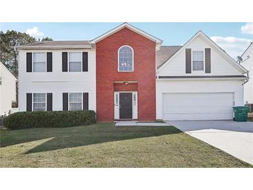 Charming two-story home featuring a red brick facade, white siding, and a well-manicured lawn at 1618 Blossom Dr, Atlanta, GA 30349