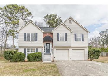 Charming two-story home with white siding, a brick entryway, attached two-car garage, and landscaped front yard at 71 Farm St, Hiram, GA 30141