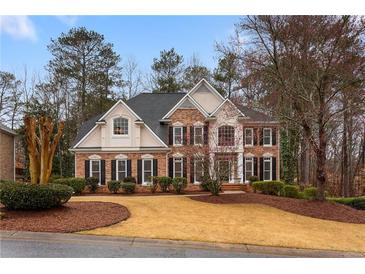 Beautiful two-story brick home featuring manicured landscaping and a well-maintained lawn at 727 Vinings Estates Se Dr, Mableton, GA 30126