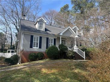 Charming home featuring a covered front porch, dormer windows and mature landscaping at 2111 Kinridge Trl, Marietta, GA 30062