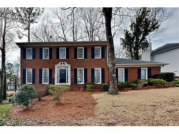 Charming two-story brick home with black shutters and a well-manicured lawn at 4614 Blakedale Cir, Roswell, GA 30075