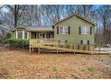 Charming two-story home with wood siding, black shutters, and a spacious front yard with a wooden ramp at 832 Toonigh Rd, Canton, GA 30115