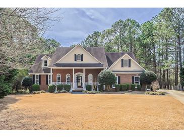 Charming two-story brick home with a inviting front porch and manicured landscaping at 1621 Annapolis Way, Grayson, GA 30017