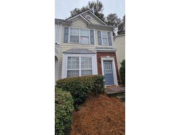 Charming two-story townhome featuring a welcoming front entrance and well-maintained landscaping at 911 Redwood Dr, Norcross, GA 30093