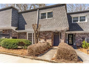 Charming townhome with brick facade, gray roof, and neatly trimmed landscaping at 1106 Hampton Ne Way, Atlanta, GA 30324