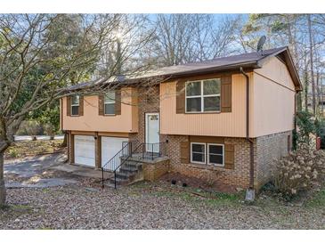 Charming split-level home with brick and siding, featuring a two-car garage and cozy front porch at 2101 Newgate Dr, Decatur, GA 30035