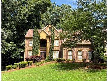 Charming two-story brick home with a well-manicured lawn and mature trees at 403 Glenhurst Trce, Canton, GA 30115