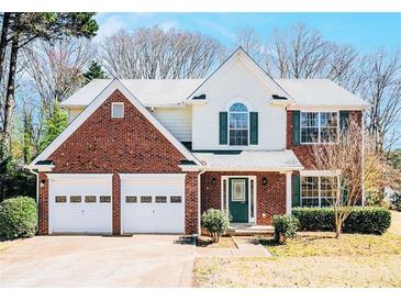 Charming two-story home with a brick front, attached two-car garage and a well-manicured lawn at 2225 Saint Thomas Way, Suwanee, GA 30024