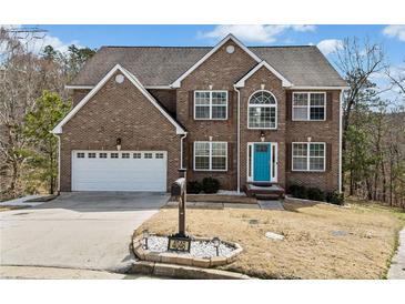 Charming two-story brick home featuring an attached two-car garage and a well-maintained front yard at 4046 Arnolds Mill Opas, Douglasville, GA 30135