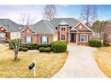 Charming brick home features a well-manicured lawn and a paved driveway leading to the entrance at 2657 Neighborhood S Walk, Villa Rica, GA 30180