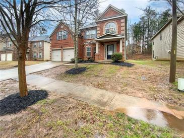 Charming two-story brick home featuring a two-car garage, front porch, and landscaped yard at 6503 Foggy Oak Dr, Fairburn, GA 30213