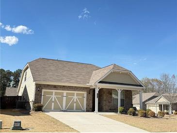 Charming home featuring a two-car garage, stone accents, and manicured landscaping at 1649 Auburn Ridge Way, Dacula, GA 30019