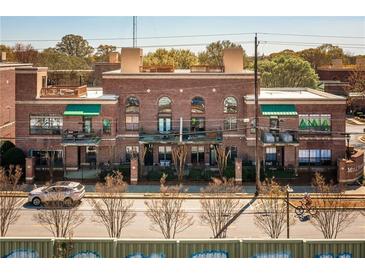 Charming brick building with awnings, balconies, and a wrought iron fence provides a unique urban living experience at 791 Wylie Se St # 105, Atlanta, GA 30316