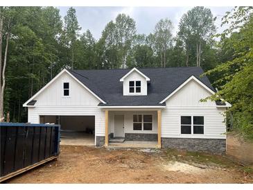 Charming new construction home featuring white siding, stone accents and an attached two car garage at 345 Evie Ln, Canton, GA 30115