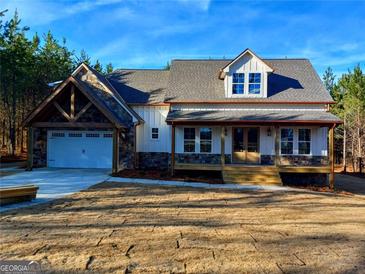 Charming two-story home with a stone and siding exterior, attached two car garage and a neatly kept front yard at 136 Rainey Rd, Temple, GA 30179