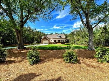 Charming two-story home with an attached garage and a beautifully landscaped front yard at 136 Rainey Rd, Temple, GA 30179